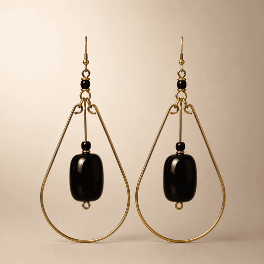 Gold teardrop earrings with a black bead in the middle.