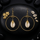 Gold hoop earrings with authentic cowrie shell in the middle.