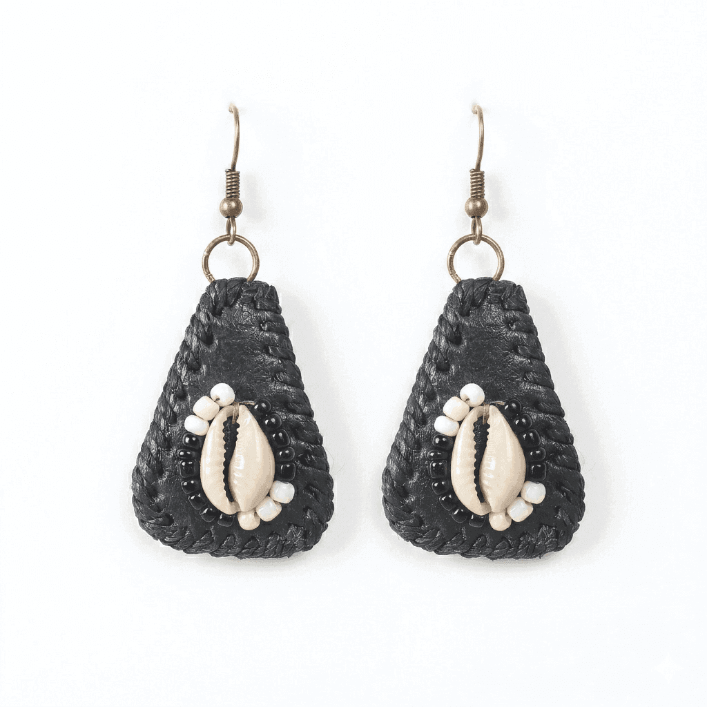 Pair of black teardrop shaped earrings with cowrie shells on a white background