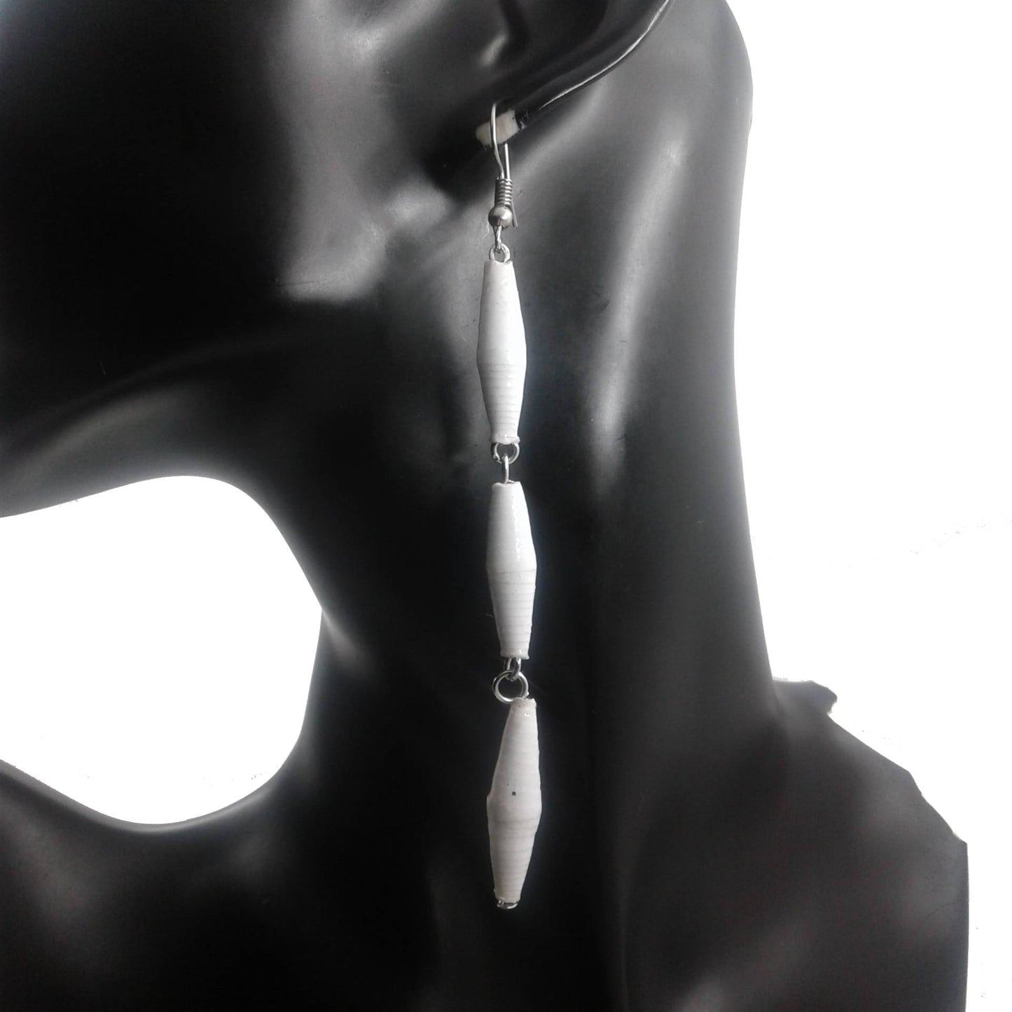 Long white earrings on a black mannequin