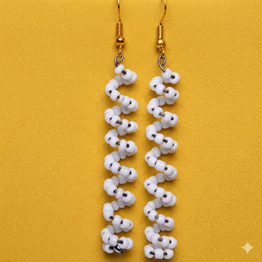 White beaded earrings on a yellow background