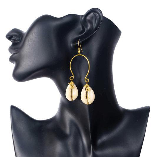 A pair of large, U-shaped gold wire earrings, each dangling two wire-wrapped natural cowrie shells.