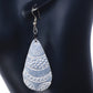 A pair of long, lightweight, silver-plated teardrop earrings with an intricate etched pattern.