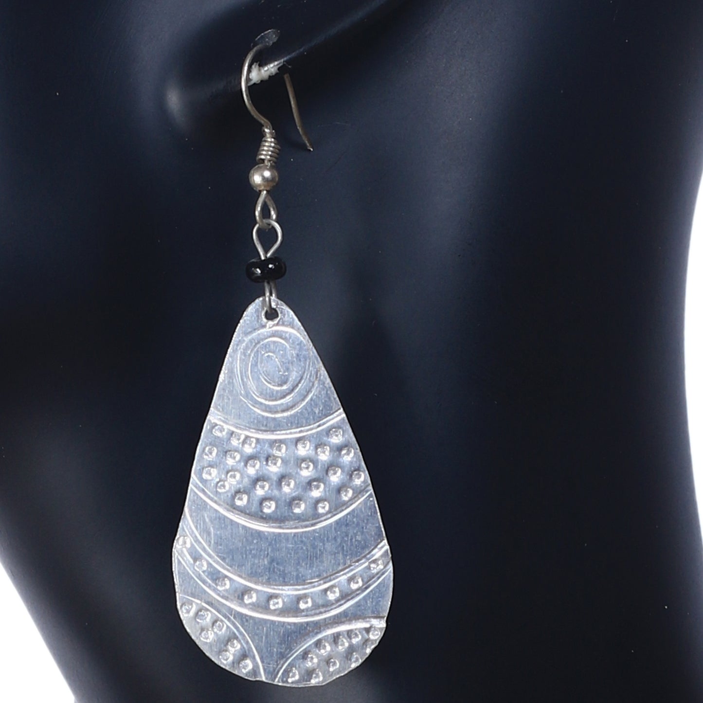 A pair of long, lightweight, silver-plated teardrop earrings with an intricate etched pattern.