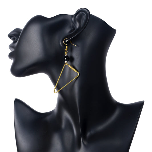 A pair of open-frame, gold-plated triangle earrings with an asymmetrically wire-wrapped side and black bead accents.