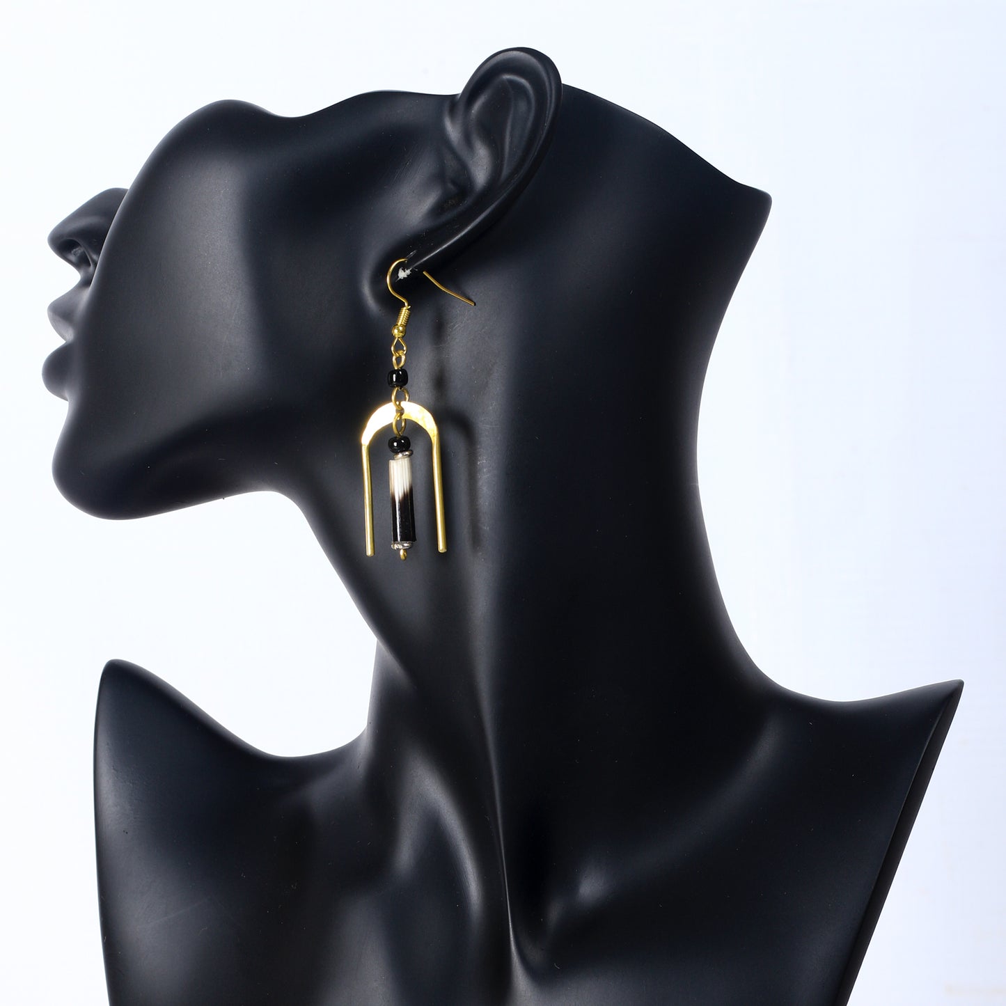 A pair of gold-plated, U-shaped arch earrings with a genuine porcupine quill dangling in the center.