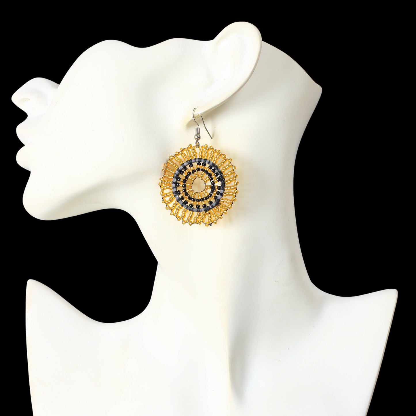 A pair of hand-woven metallic gold and black beaded disc earrings.