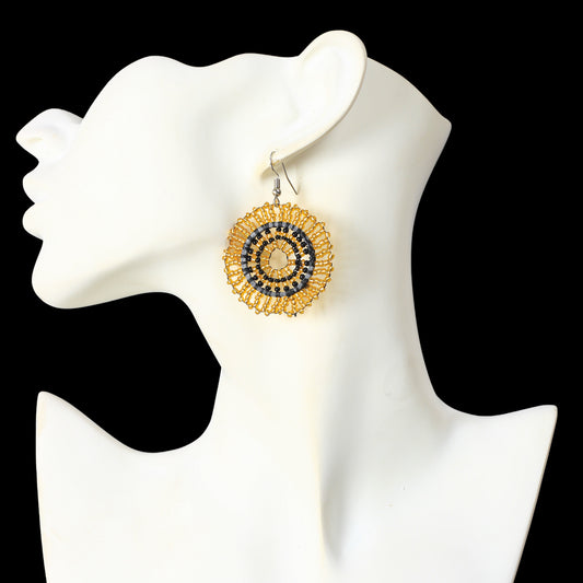 A pair of hand-woven metallic gold and black beaded disc earrings.