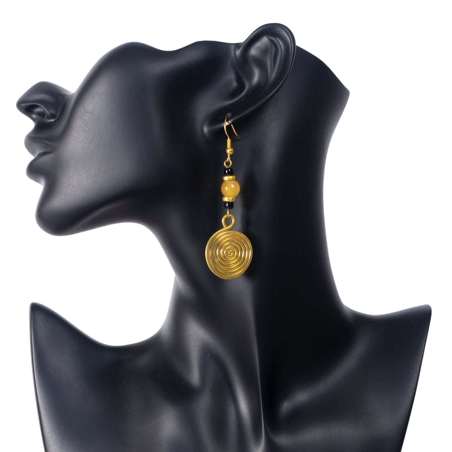 A pair of long, gold-plated dangle earrings with a marbled yellow bead and a large, coiled spiral disc.