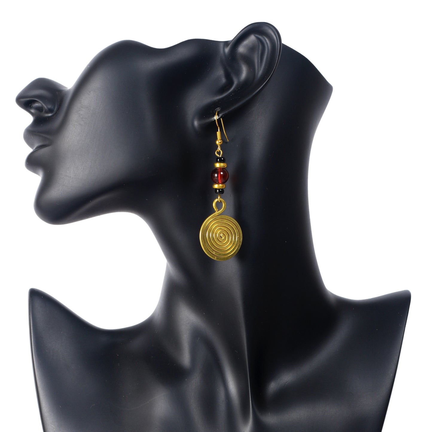 A pair of long, gold-plated dangle earrings with a large, translucent red bead and a large, coiled spiral disc.