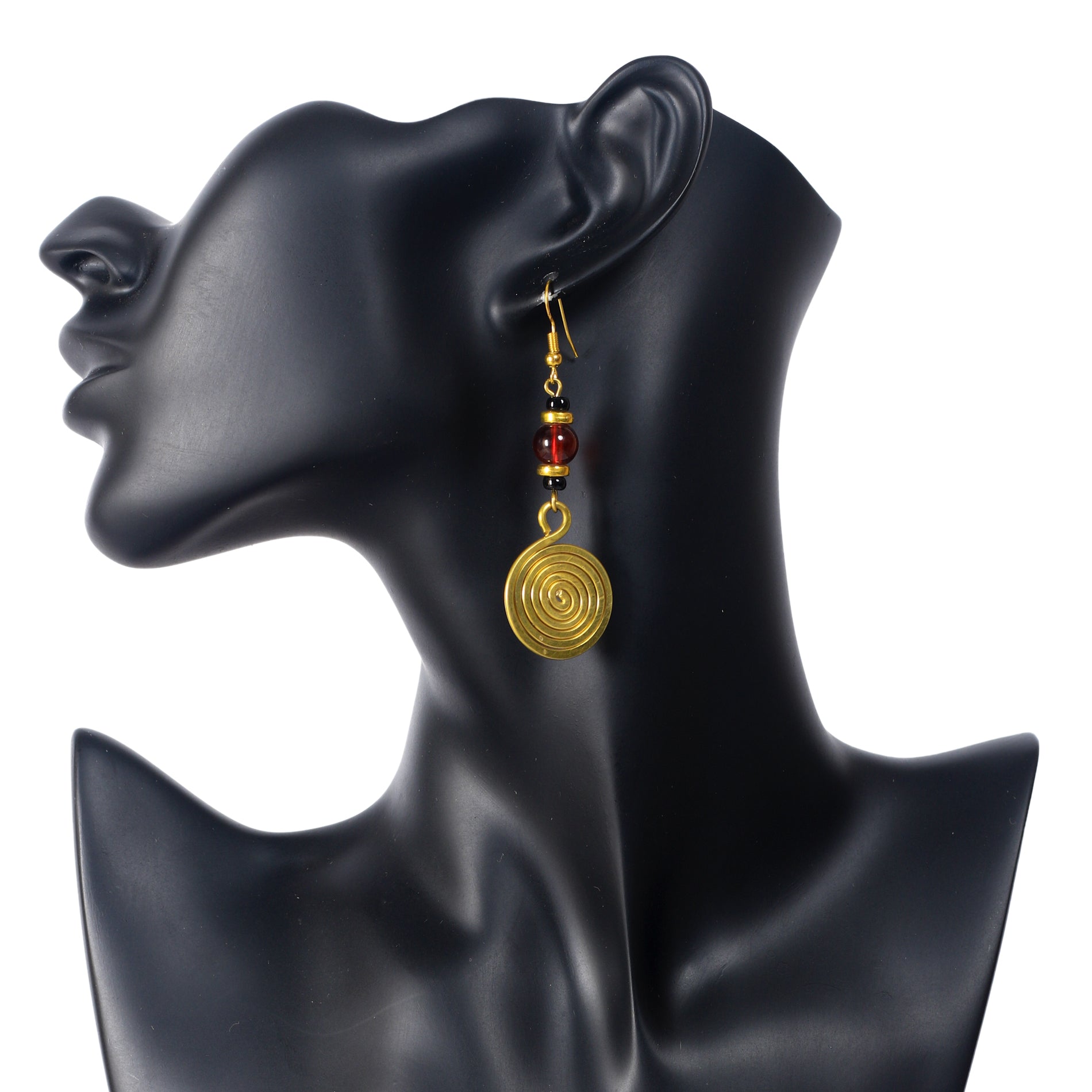 A pair of long, gold-plated dangle earrings with a large, translucent red bead and a large, coiled spiral disc.