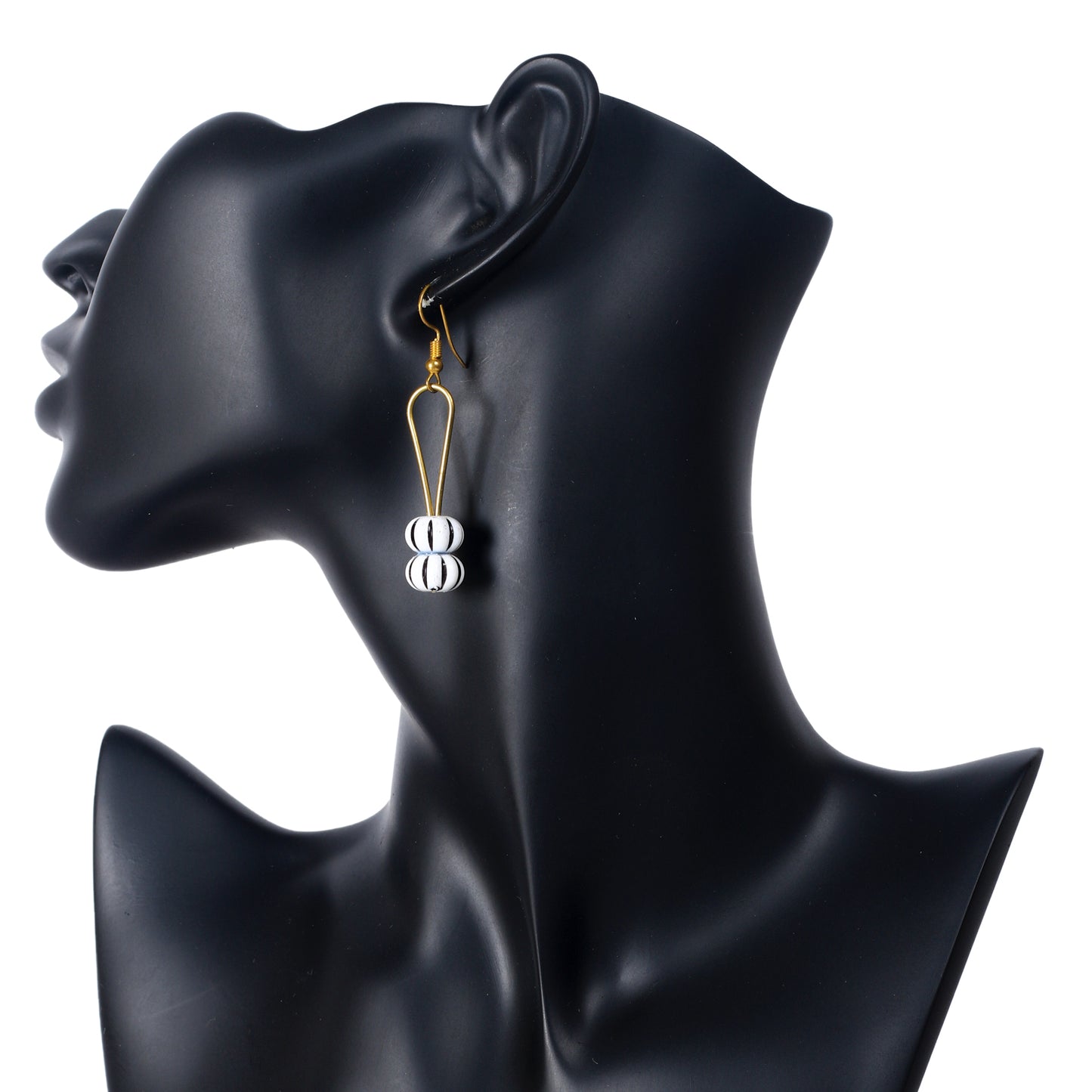 A pair of gold-plated U-shaped earrings dangling two round, black-and-white striped beads.