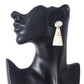 Handmade geometric camel bone earrings with an oval stud and cream tapered drop, accented with gold inlay lines.