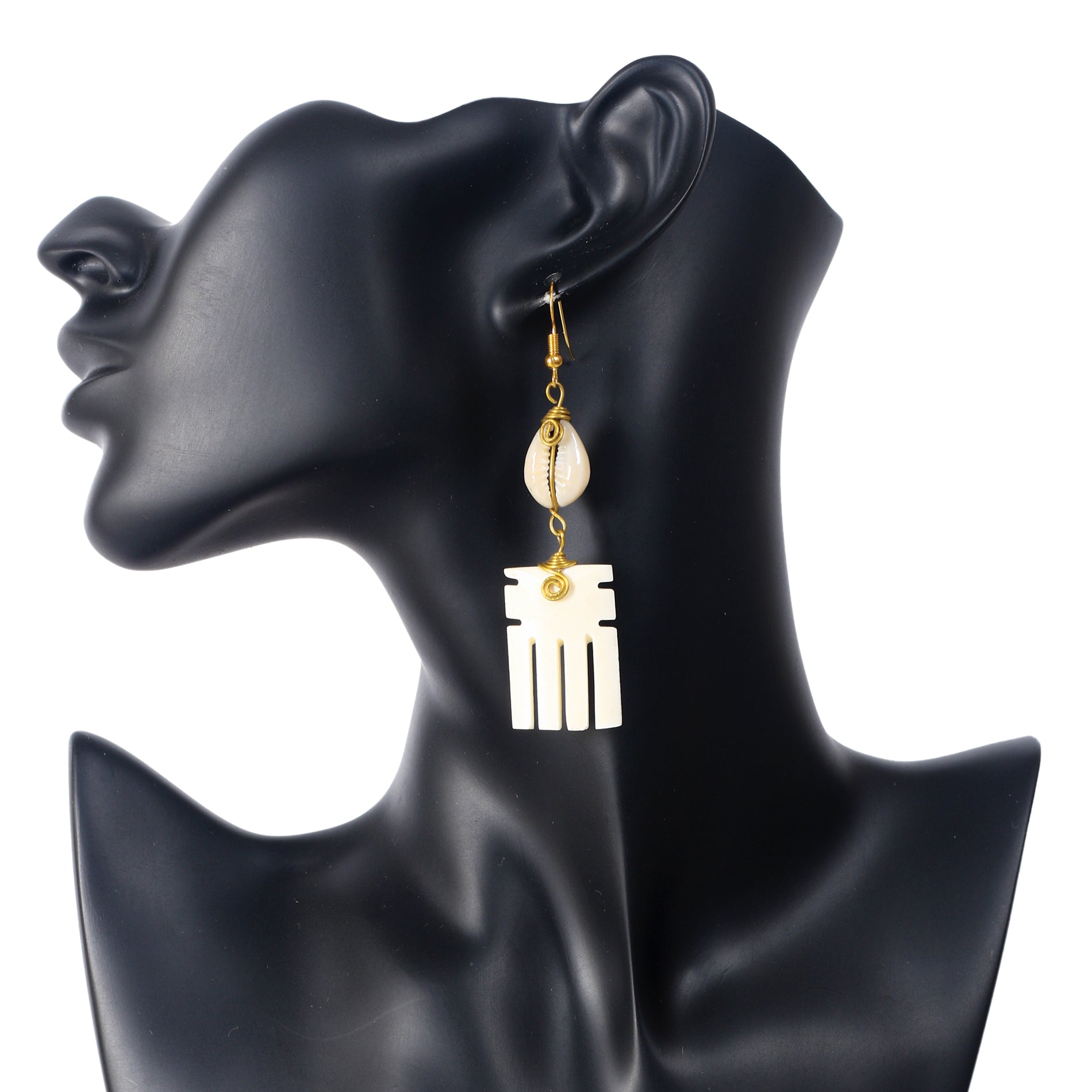 Handmade dangle earrings featuring a wire-wrapped cowrie shell stacked above a carved, comb-shaped camel bone drop.