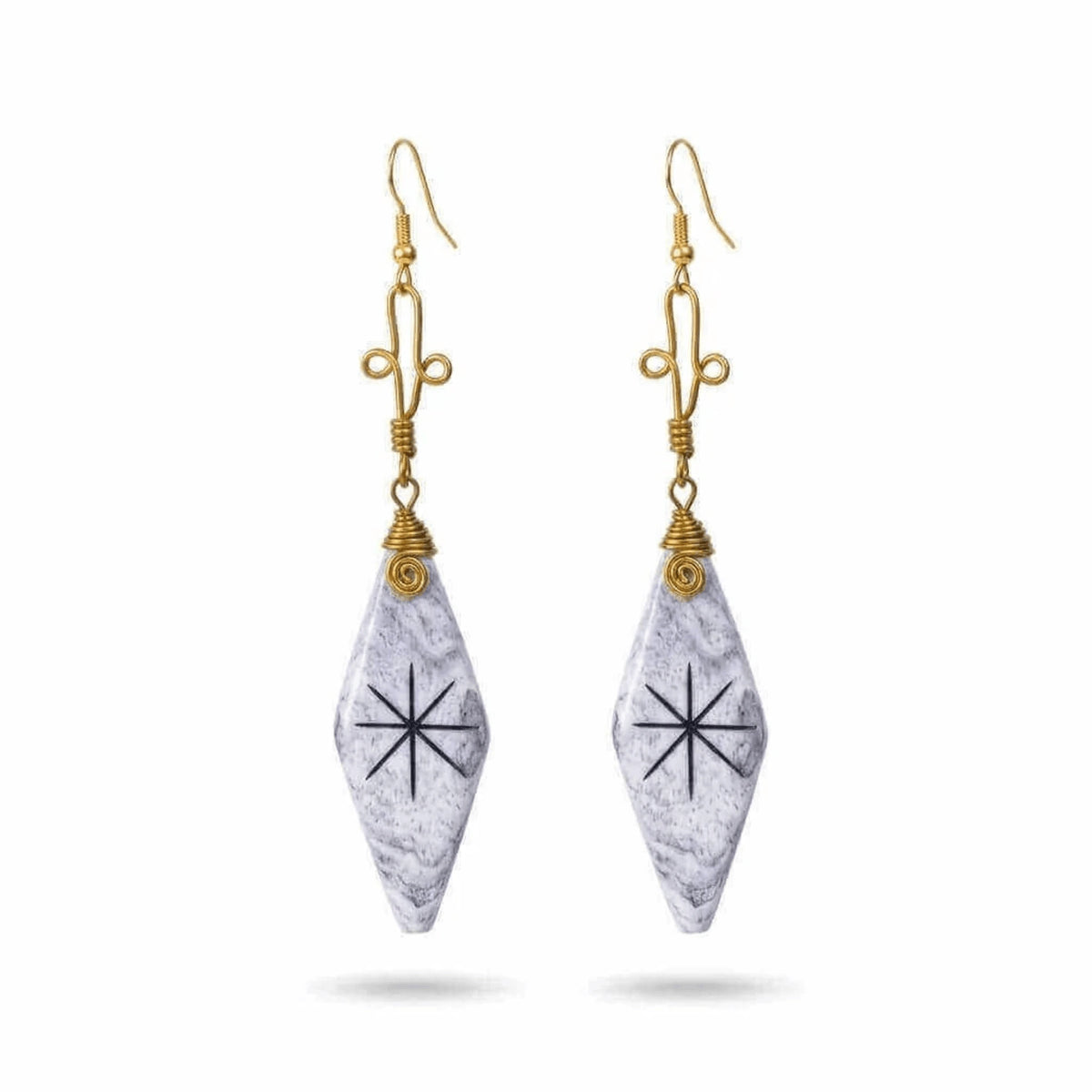 A pair of dangle earrings featuring white and gray camel bone pendants with a black starburst symbol.