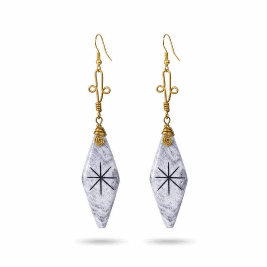 A pair of dangle earrings featuring white and gray camel bone pendants with a black starburst symbol.