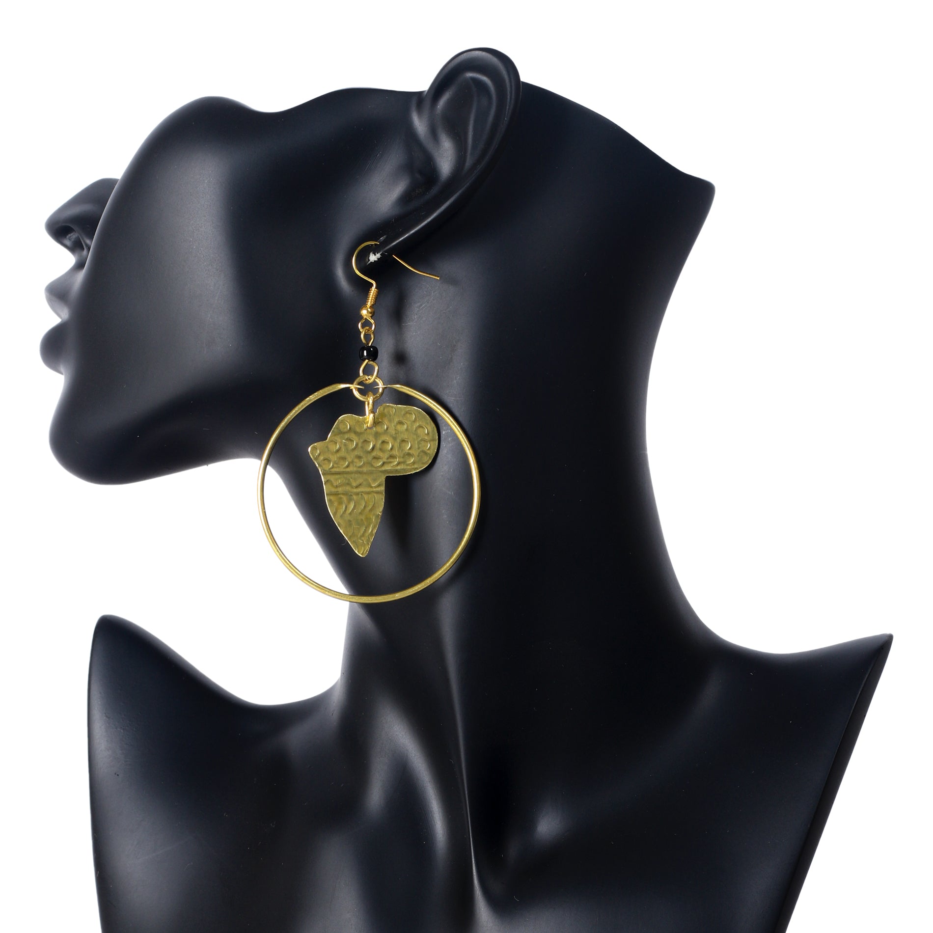 A pair of large, gold-plated hoop earrings with an etched Africa map pendant suspended in the center.