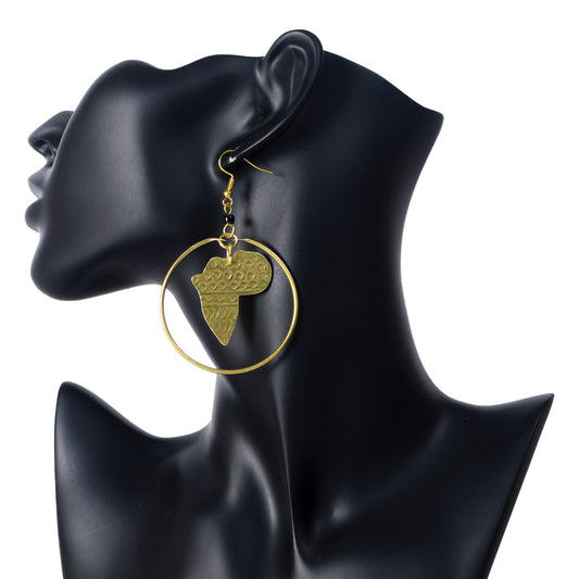 A pair of large, gold-plated hoop earrings with an etched Africa map pendant suspended in the center.
