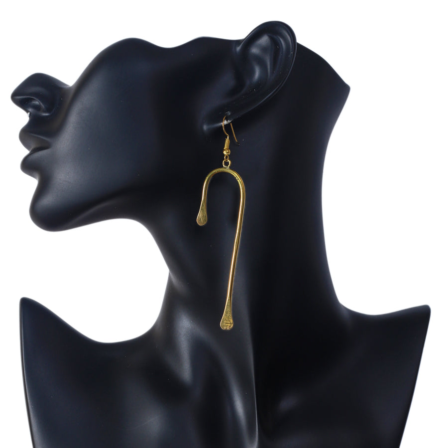 A pair of long, modern, gold-plated dangle earrings in a sculptural U-shape with flattened ends.