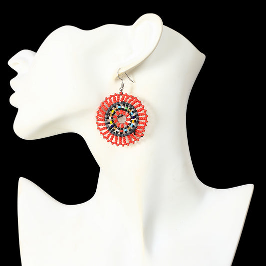 A pair of hand-woven red beaded disc earrings with a multicolor inner concentric circle pattern.